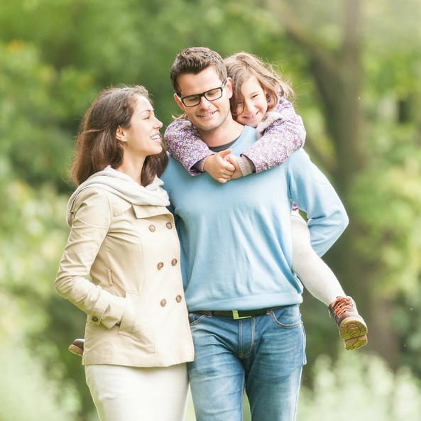parents and kid walking in park