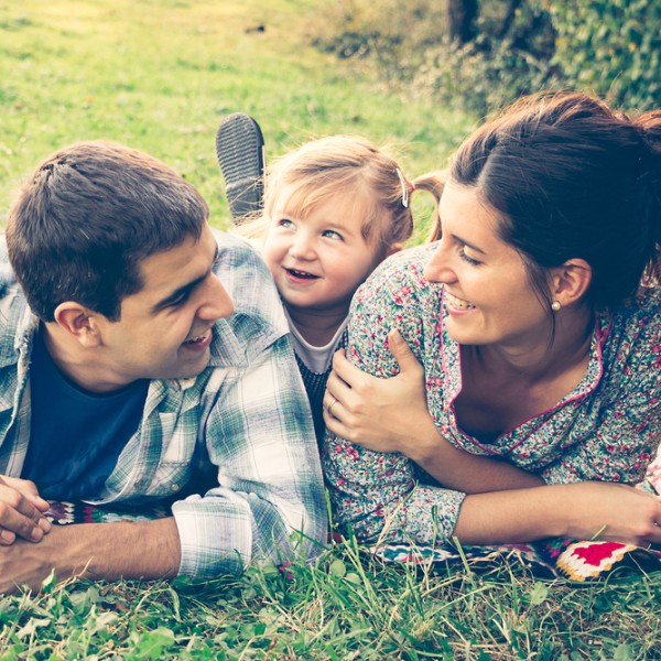 parents smiling with kid at park